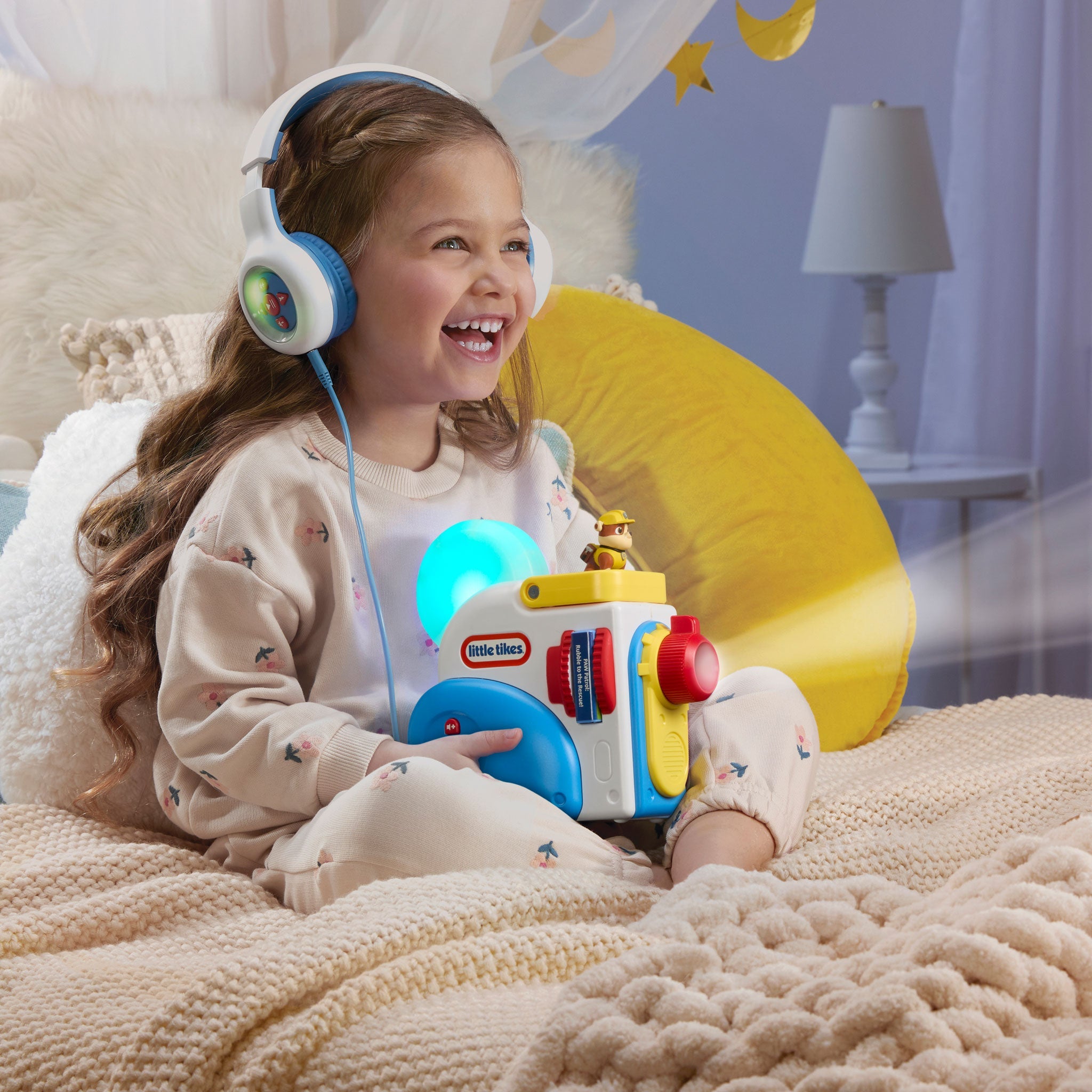 Child wearing headphones holding a 
Story Dream Machine in a cozy room