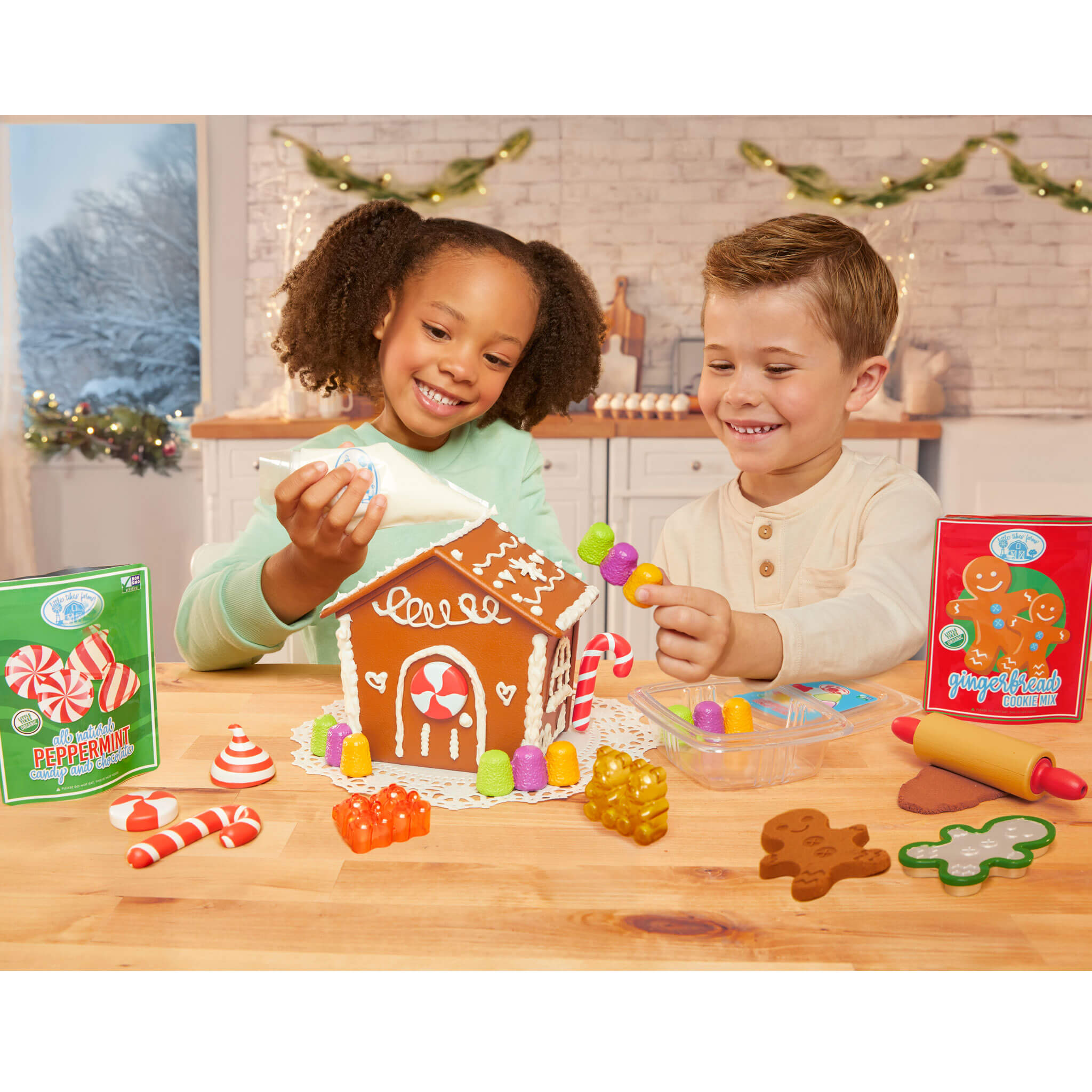 Two children playing with a gingerbread house kit